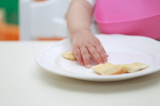 手でご飯を食べる赤ちゃん